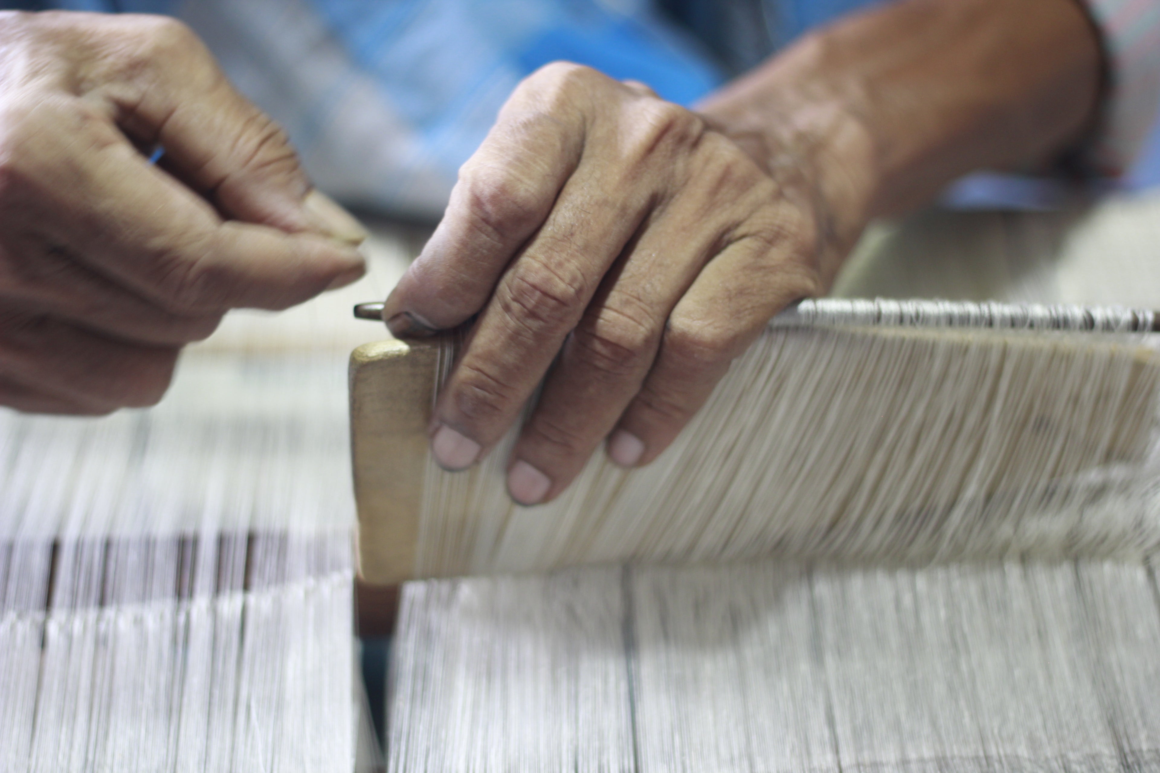 Load video: Weavers weaving textile